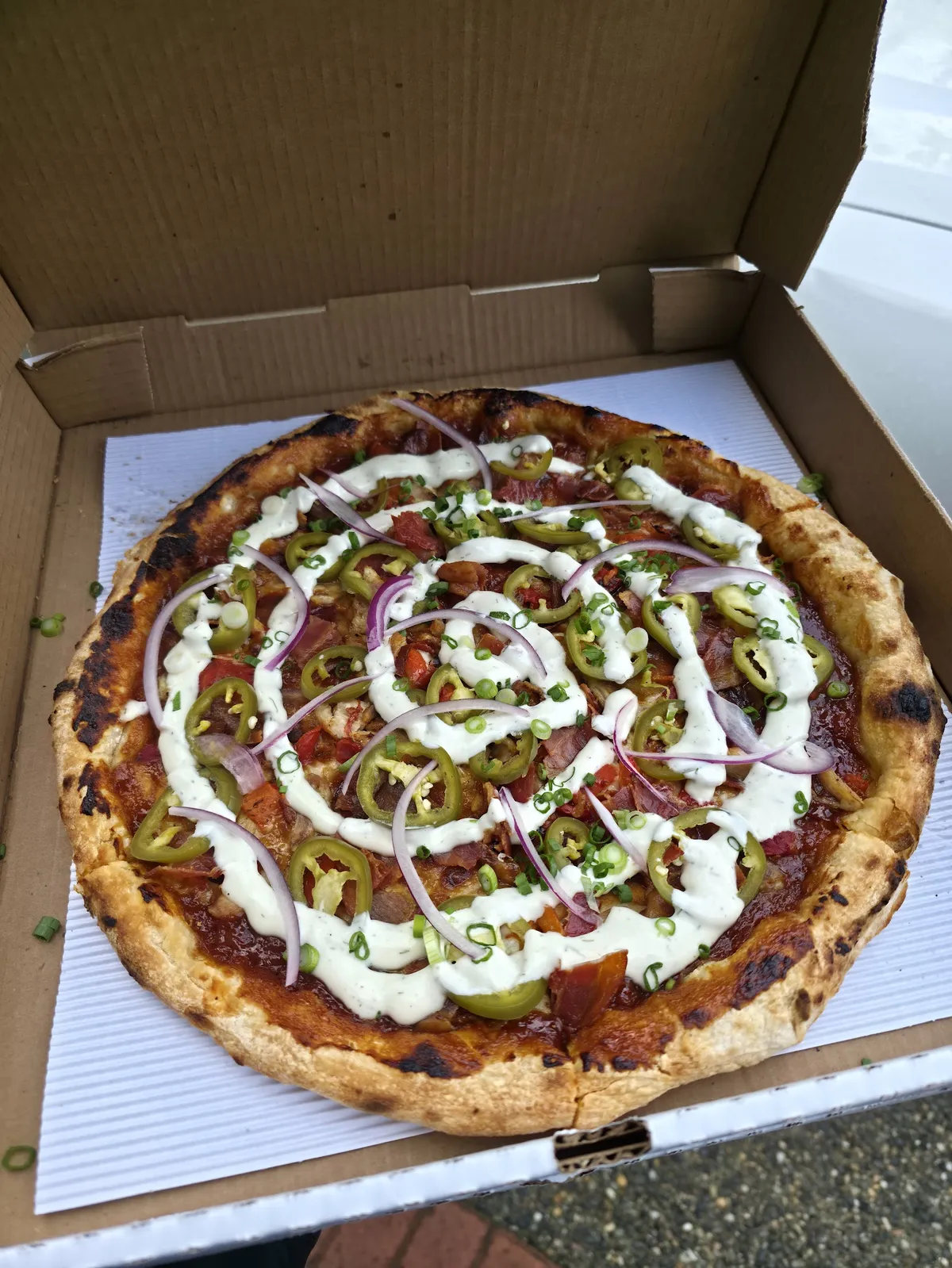 Pizza with various toppings in a cardboard box
