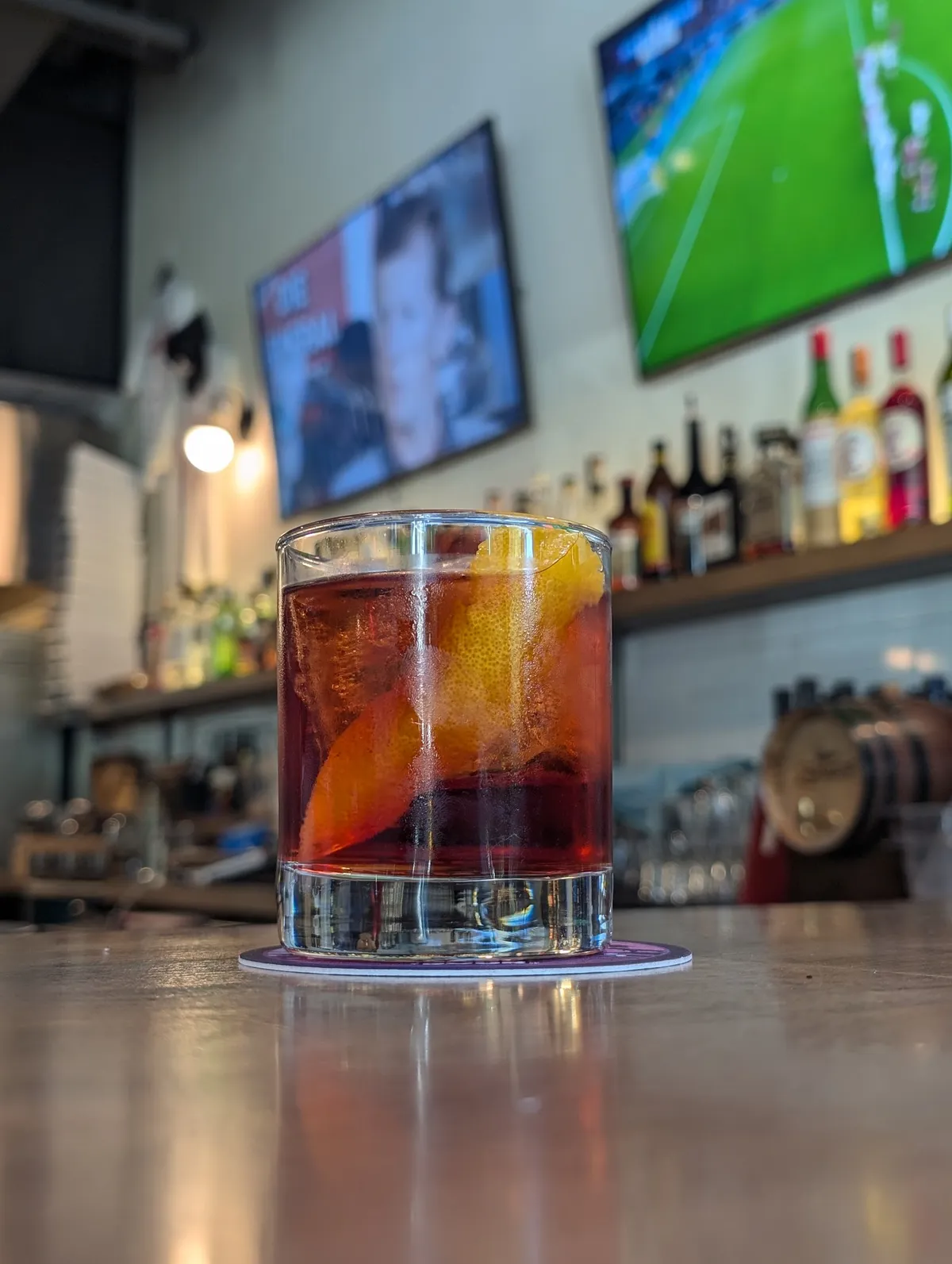 Cocktail with orange peel on a bar counter